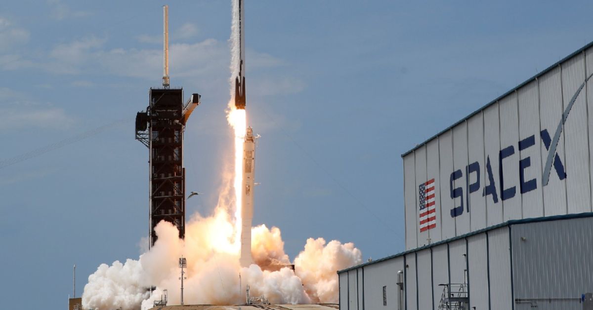 Foguete da SpaceX decola durante lançamento nos Estados Unidos enquanto fumaça cobre a base operacional da empresa.