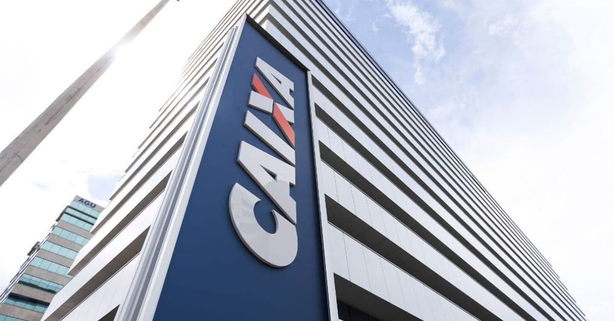 Fachada de prédio da Caixa Econômica Federal vista de baixo para cima, com logotipo do banco em destaque em edifício corporativo.