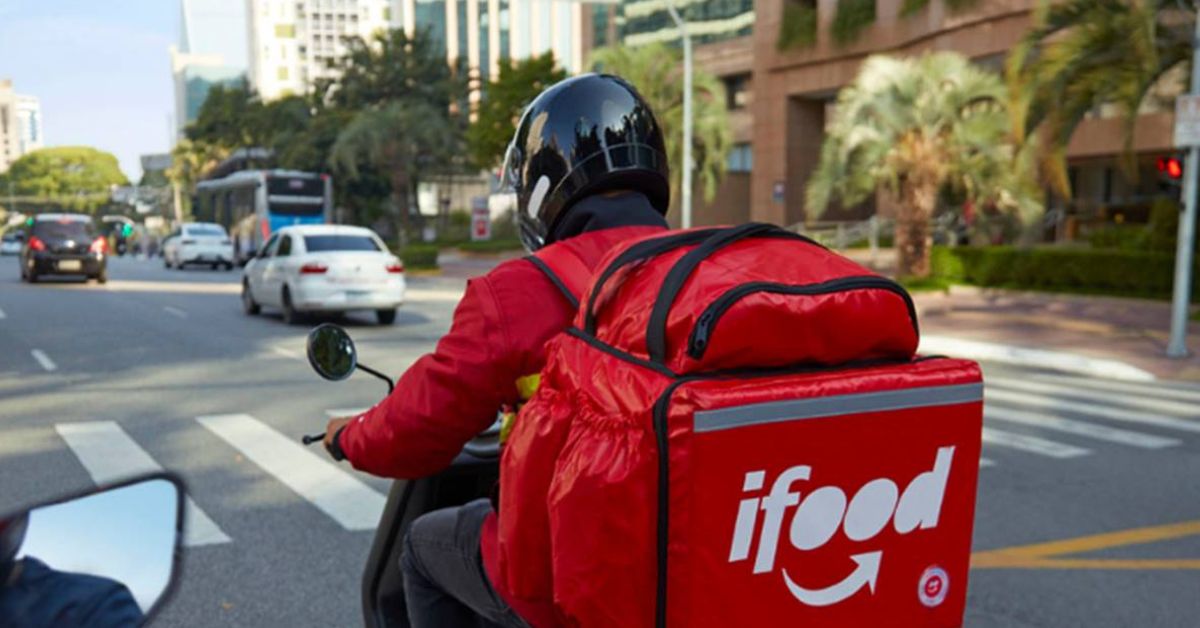 Entregador de aplicativo realiza entrega de motocicleta em área urbana, tema relacionado ao financiamento de motos para entregadores discutido pelo governo federal.