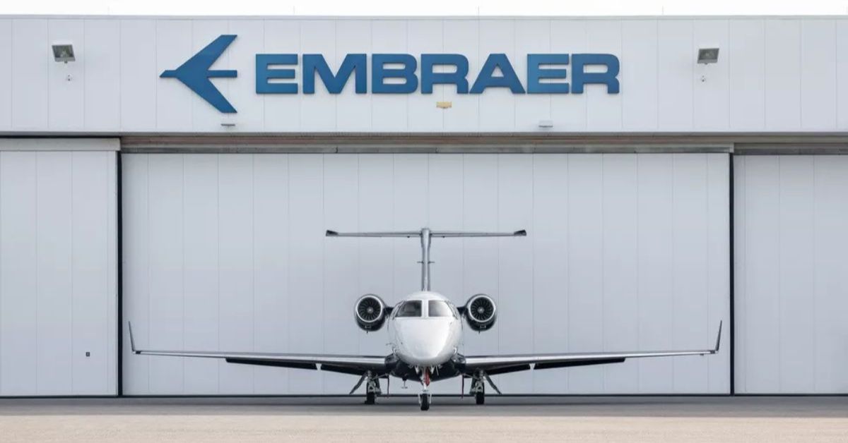 Avião da Embraer posicionado em frente a um hangar da fabricante, em imagem usada para ilustrar proposta de garantia pública para financiamentos de aeronaves.