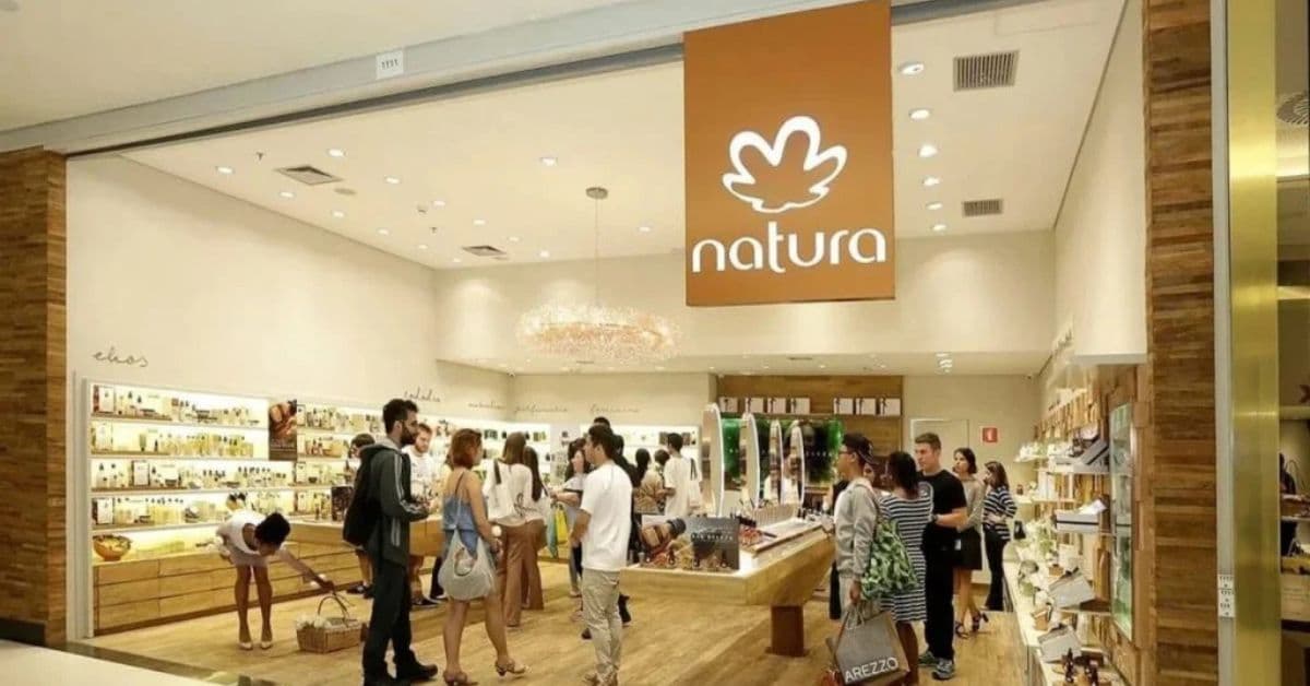 Loja da Natura com consumidores circulando entre prateleiras de cosméticos e produtos de beleza, imagem que ilustra a parceria entre Natura e CadÚnico para capacitação e geração de renda.