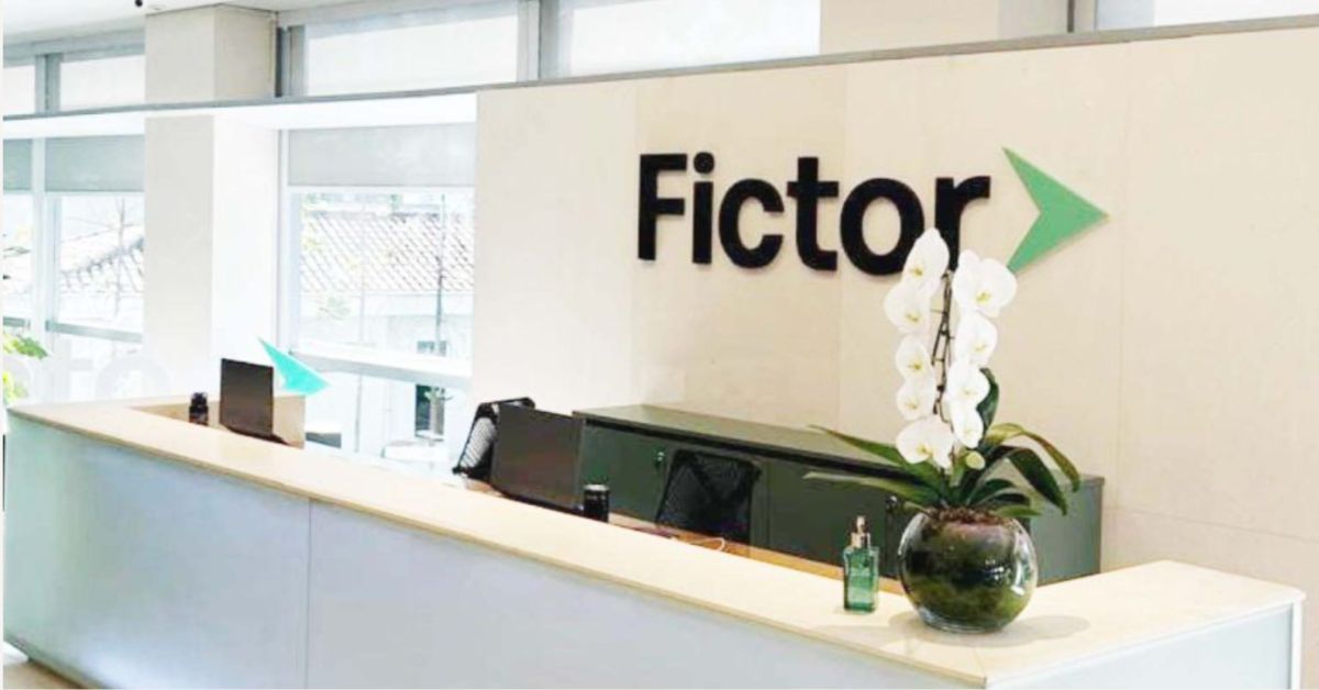 Recepção de escritório da Fictor com logotipo da empresa em destaque na parede, em imagem associada ao plano de recuperação judicial do grupo.