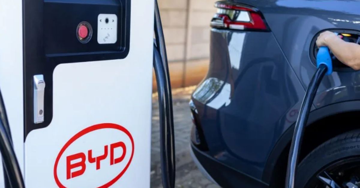 Carro elétrico da BYD conectado a estação de carregamento durante recarga, em imagem que ilustra a expansão da infraestrutura para veículos elétricos.