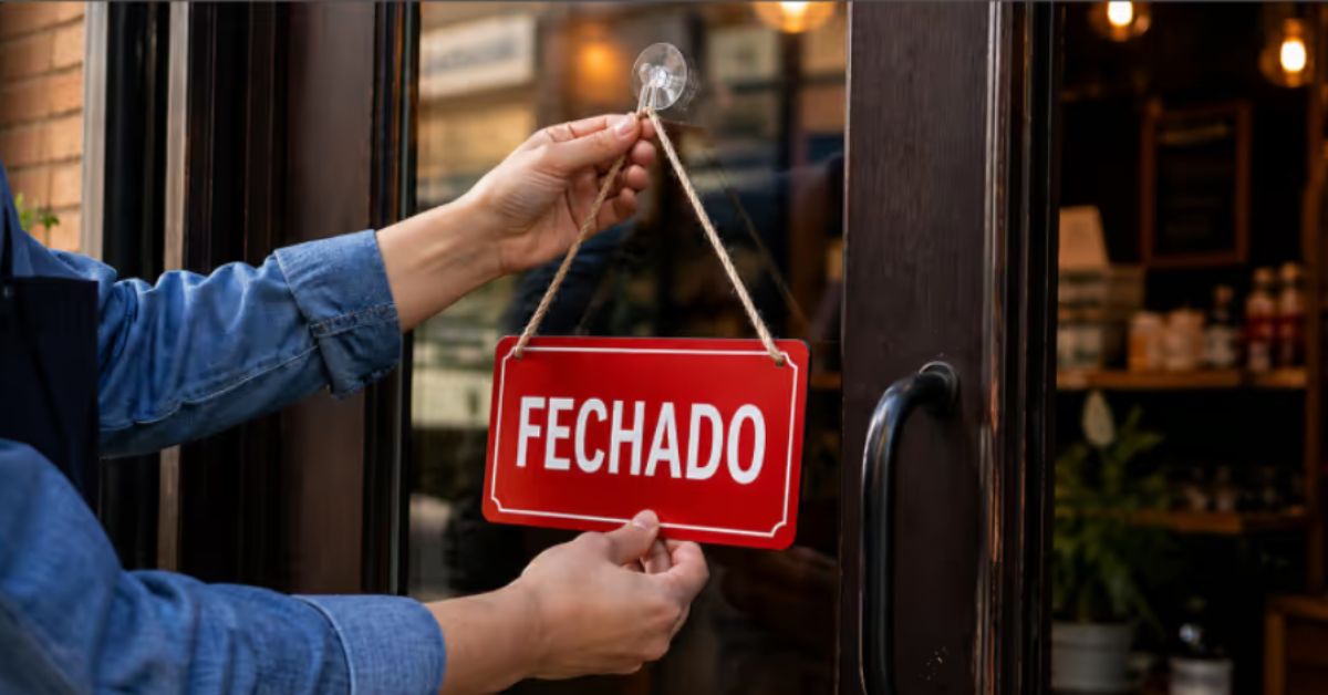 Placa de “fechado” é colocada na entrada de um estabelecimento comercial, ilustrando os impactos das novas regras para funcionamento do comércio em feriados.
