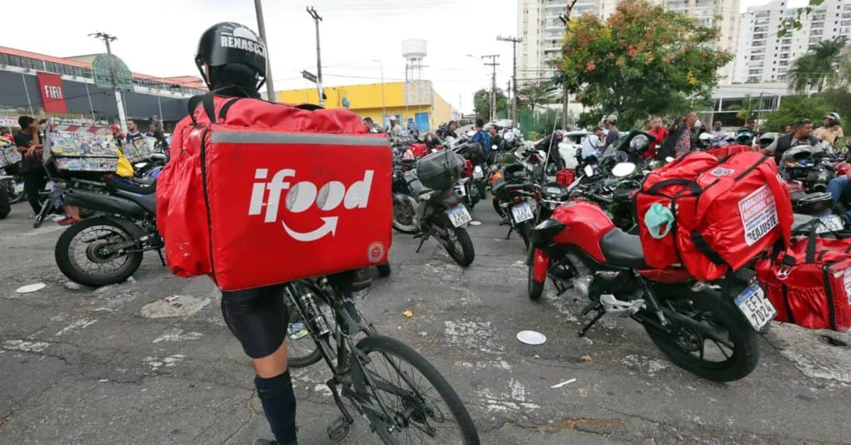 Entregador de aplicativo participa de mobilização com motociclistas em área urbana.