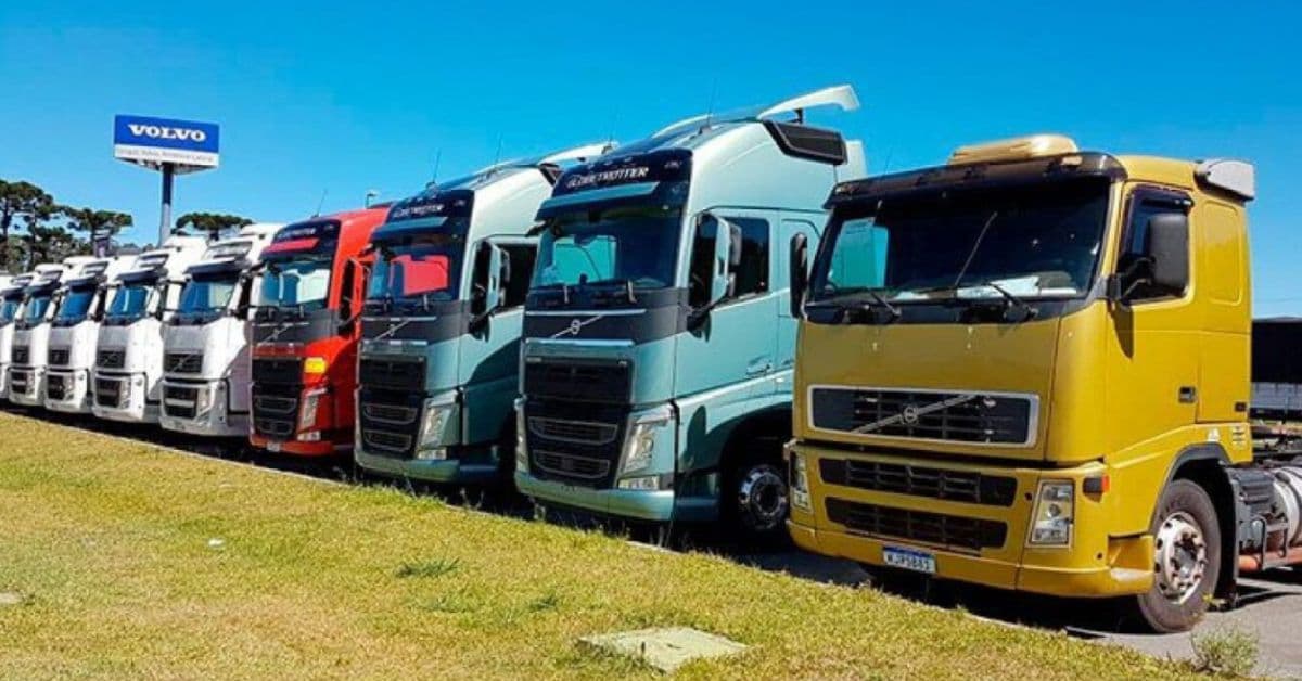 Fileira de caminhões dispostos ilustrando venda de caminhões que movimenta mercado de caminhões